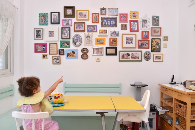 תמר מתבוננת בקיר תמונות